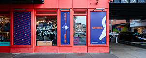 Exterior of Artists & Fleas Chelsea Market with red wall and purple logo
