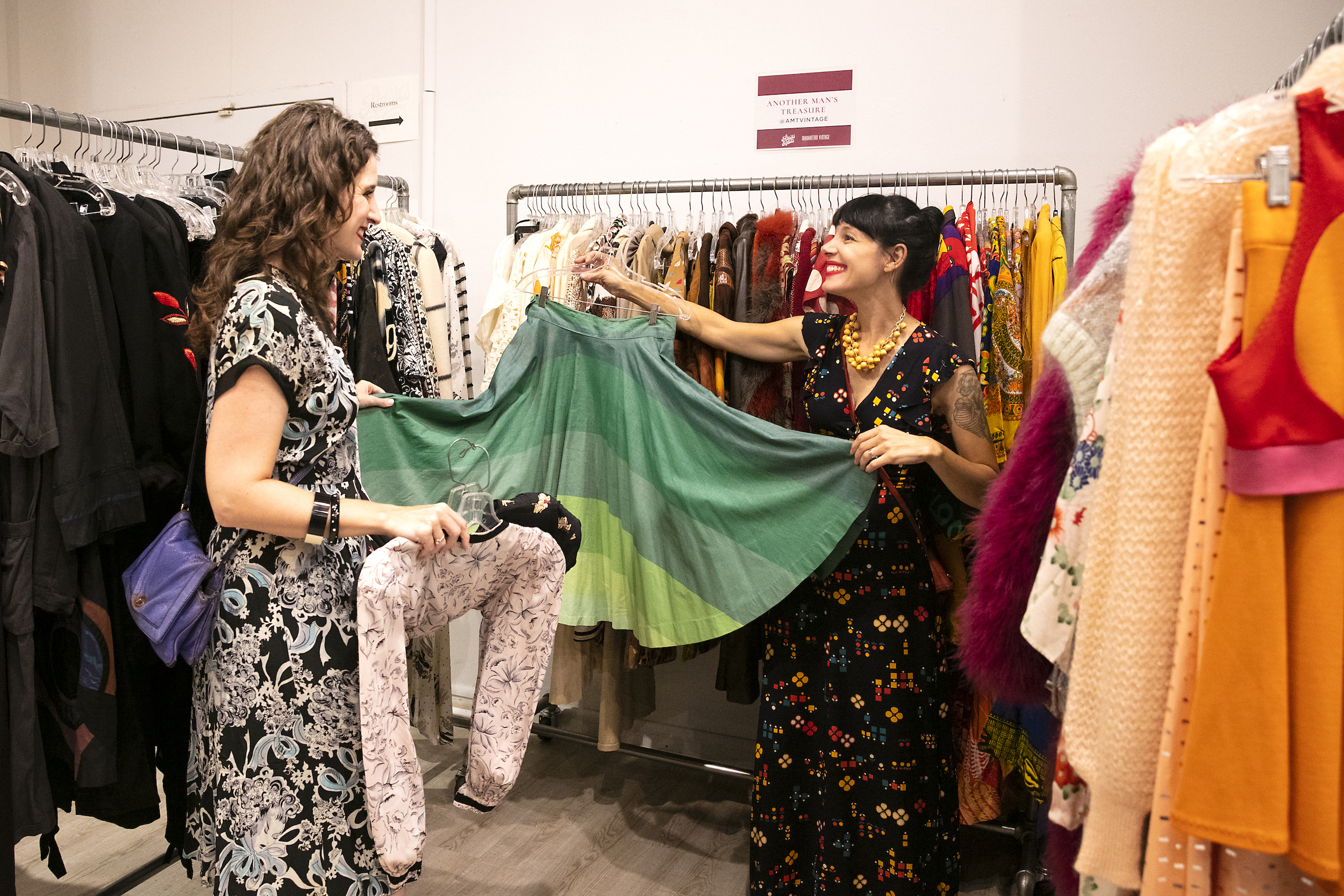 Vintage dealer at Artists & Fleas Vintage Showcase event holding colorful skirt with a shopper