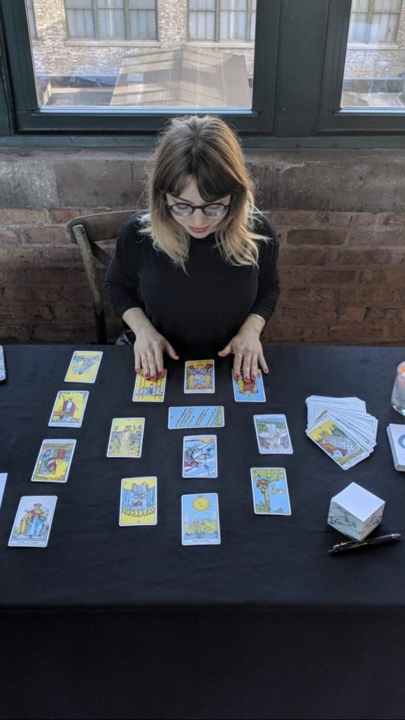 Woman reading tarot cards laid out on a table.