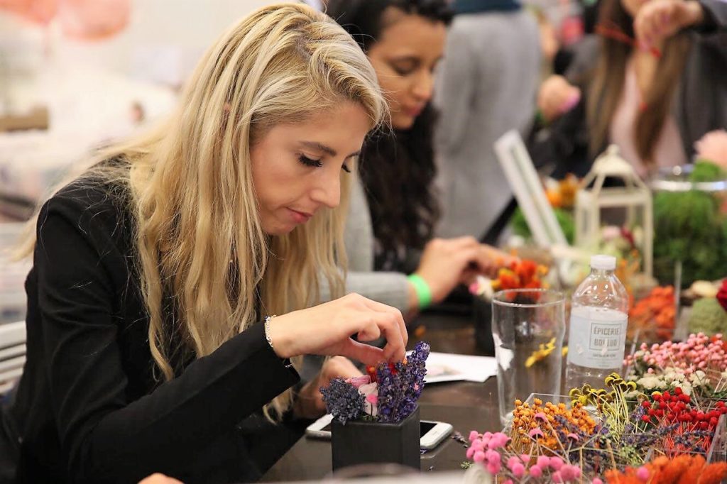 woman working on a DIY preserved flower arrangement