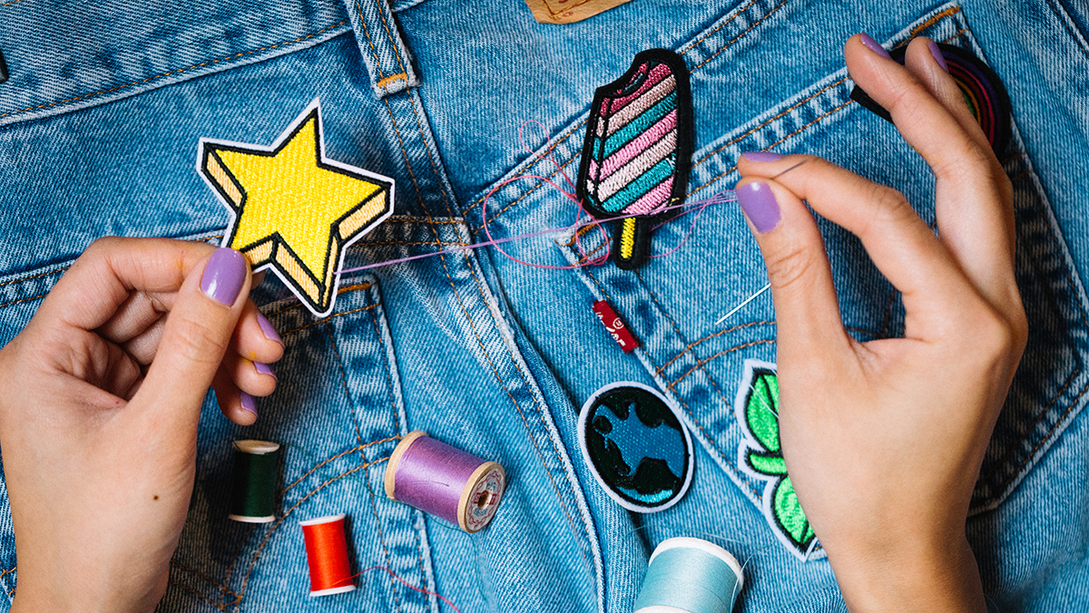 Woman sewing patches on Levis jeans