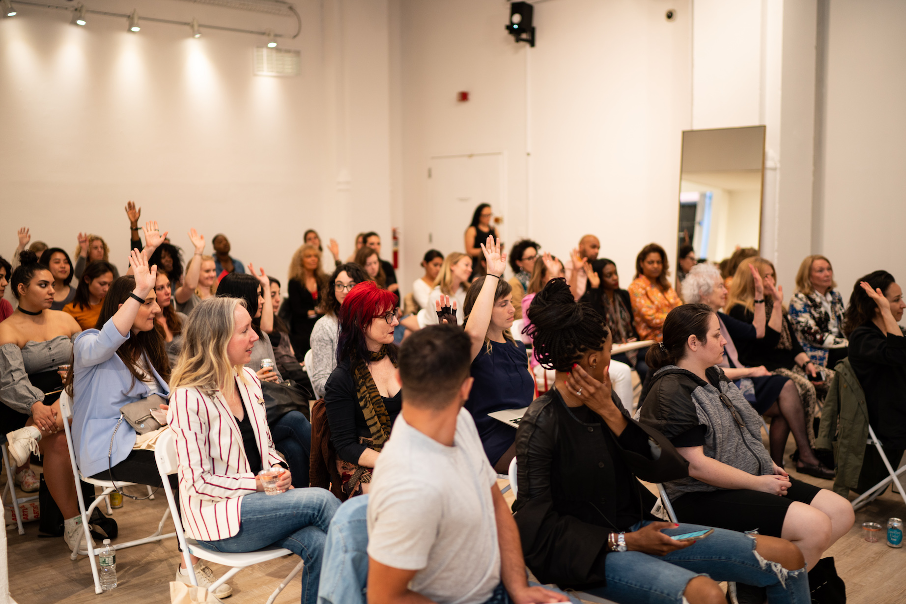 People raising hands at an event